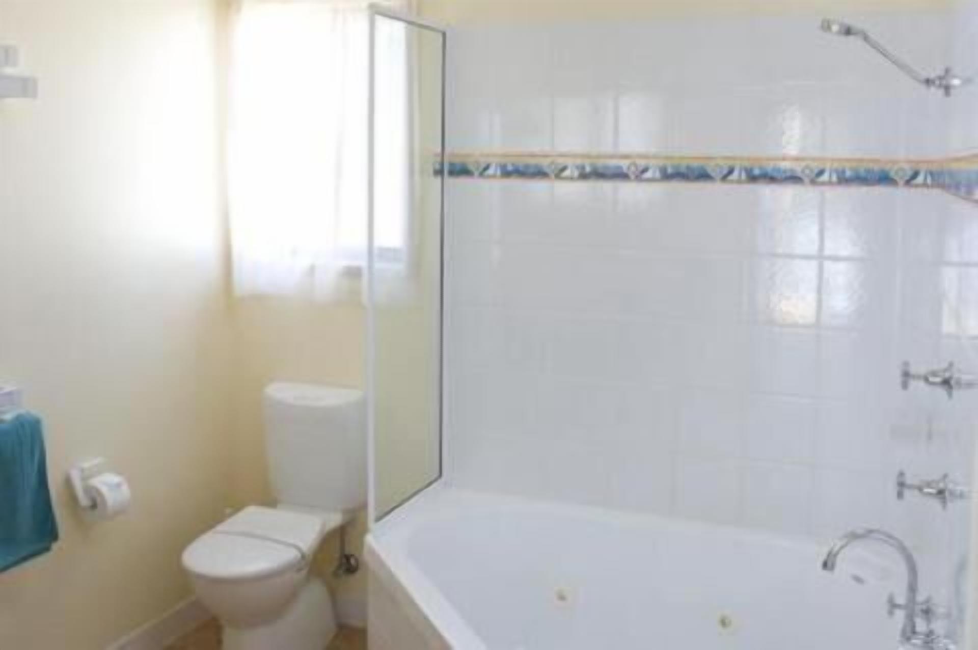 A bathroom with a toilet, a bathtub, and a shower.