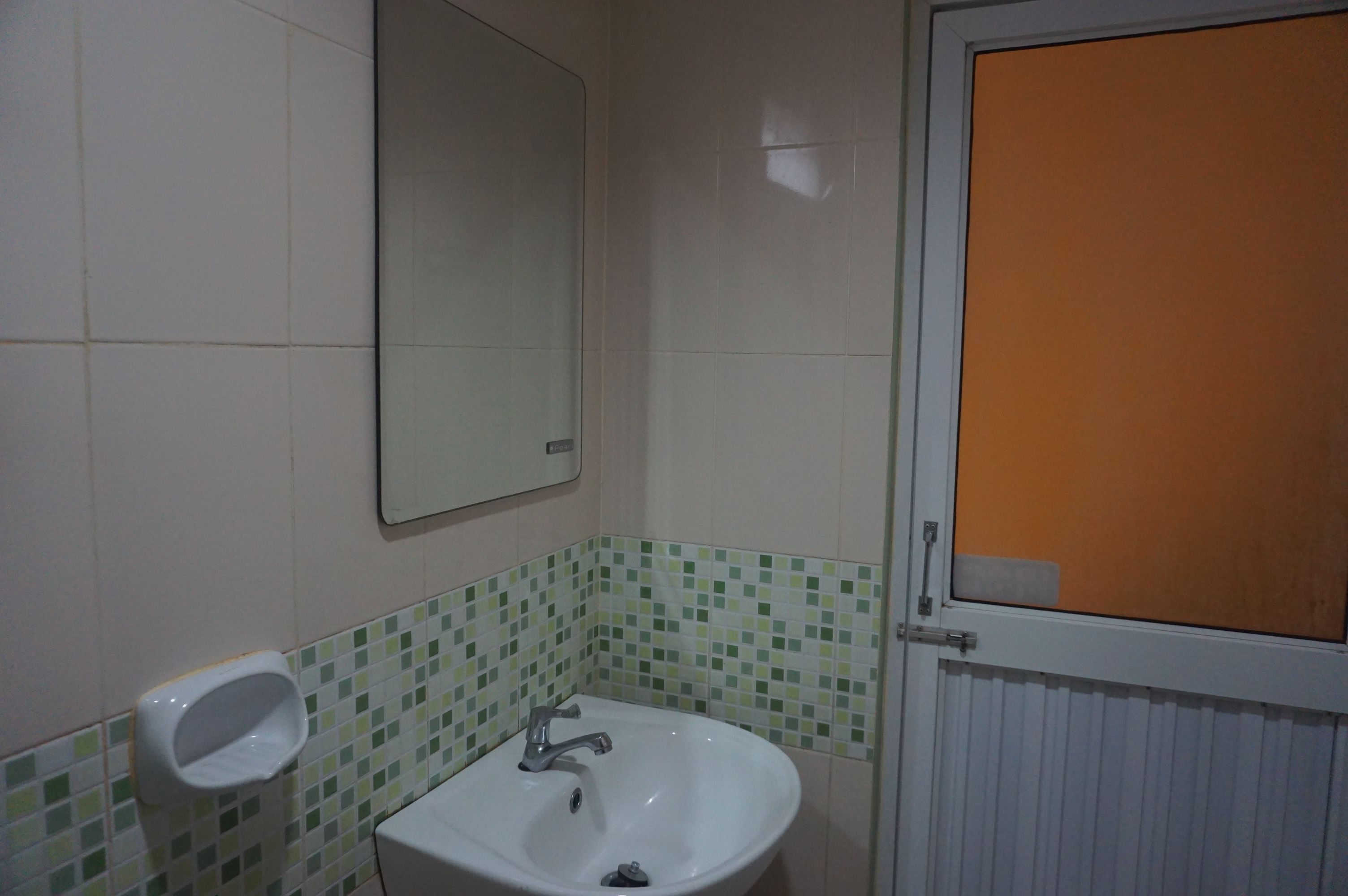 Un baño con lavamanos, espejo e inodoro.