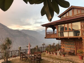 Un bâtiment en bois doté d’un balcon donnant sur un paysage montagneux.