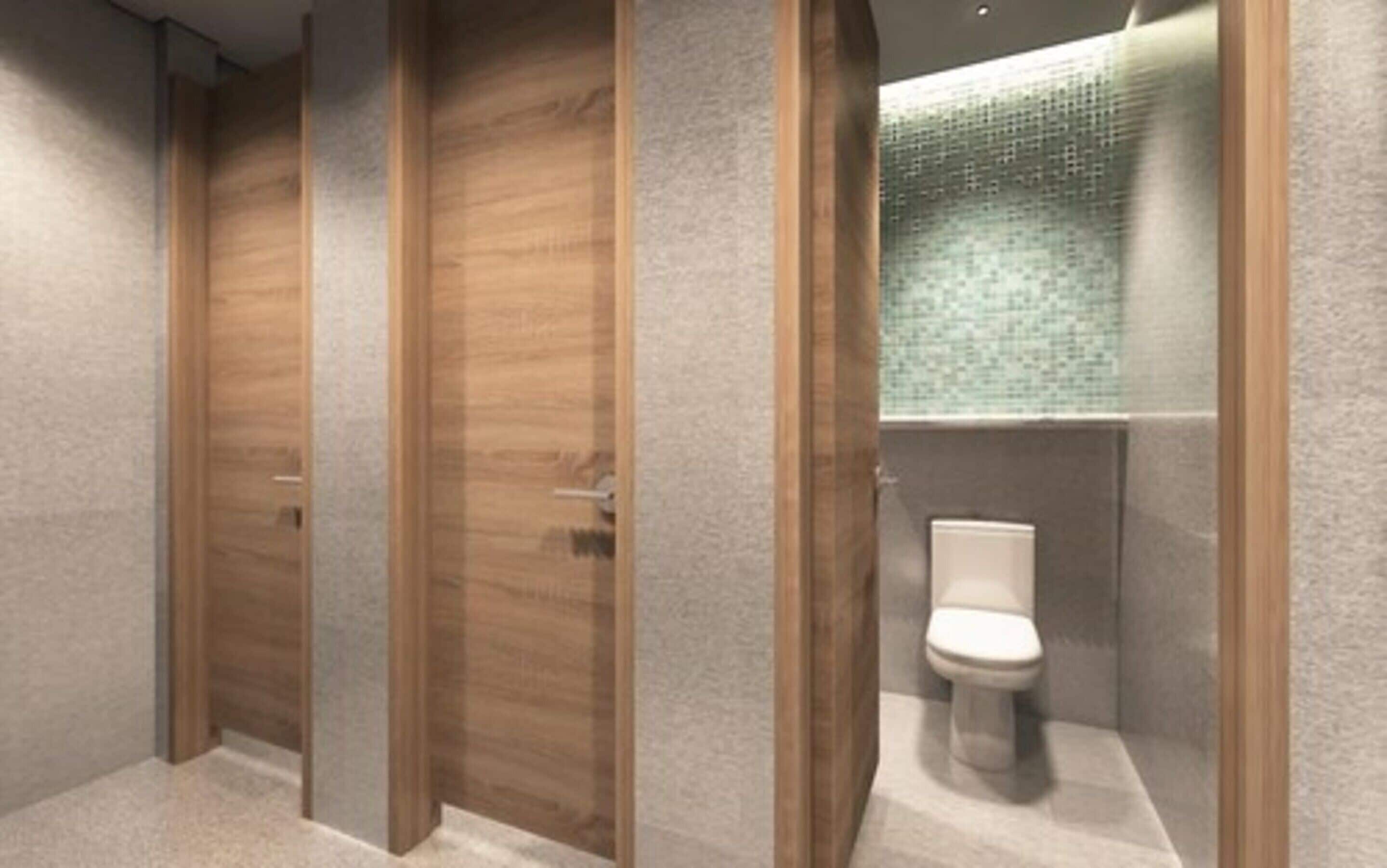 A modern bathroom with wooden doors, a tiled shower area, and a toilet.