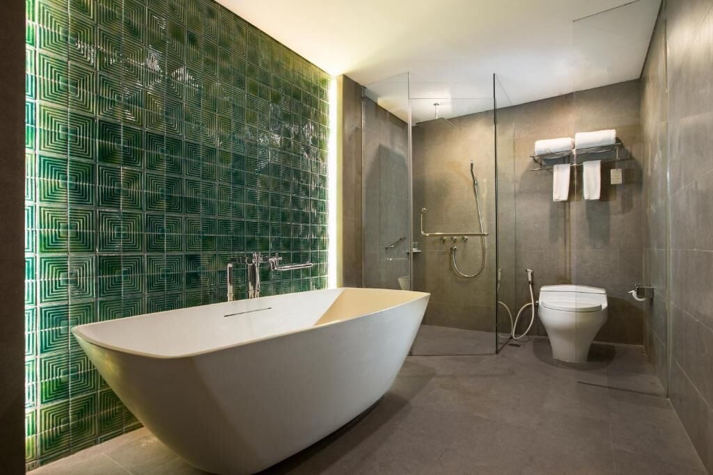 A modern bathroom with a freestanding bathtub, a glass-enclosed shower, and a toilet with a towel rack.