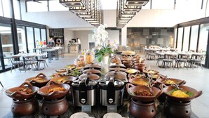 Buffet-pöytä, jossa on tarjolla monenlaista ruokaa ja ruoanlaittovälineitä.