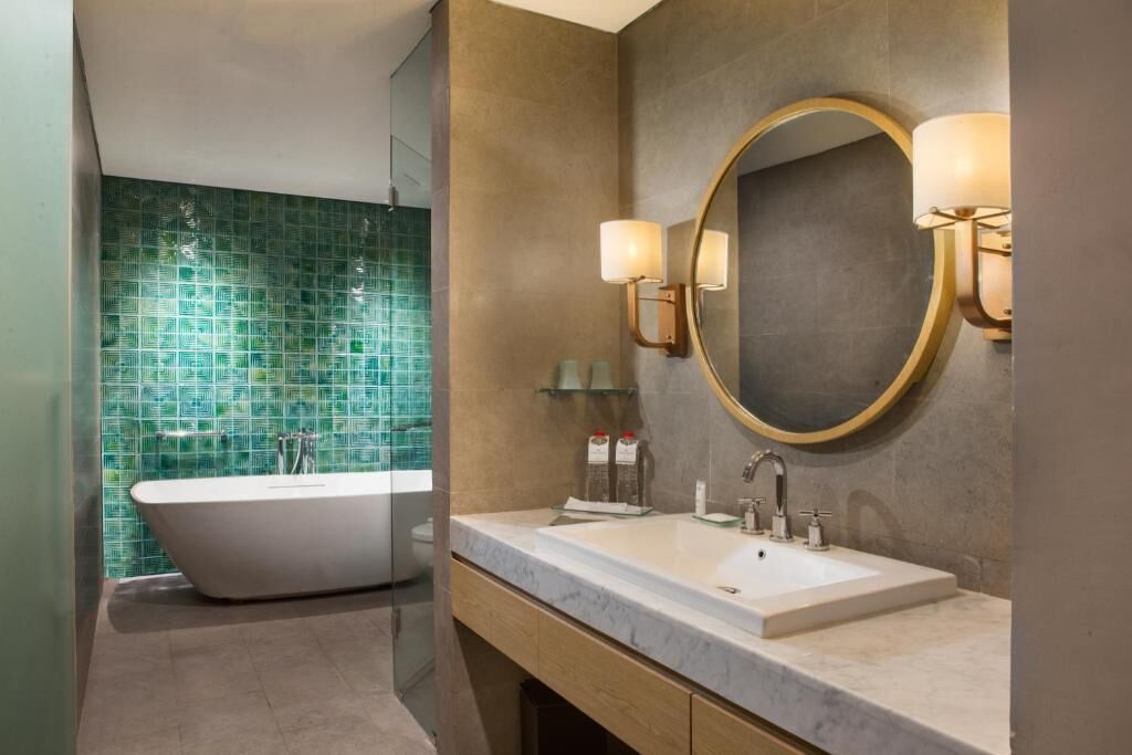 A modern bathroom with a freestanding bathtub, a large mirror, and a double sink vanity.
