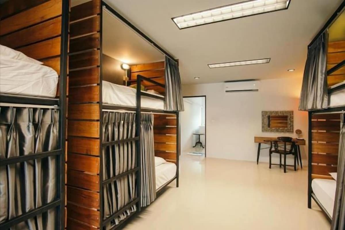 A modern hotel room with bunk beds, a desk, and a chair.