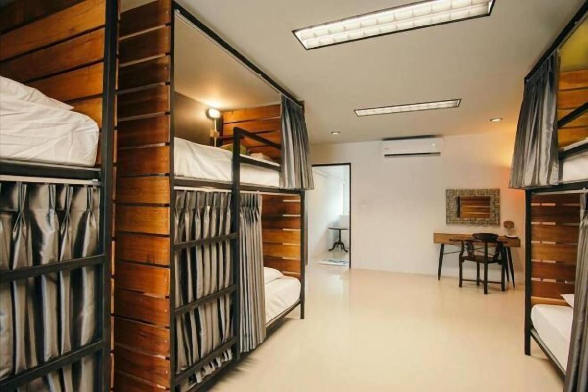 A modern hotel room with bunk beds, a desk, and a chair.
