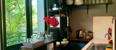 A modern kitchen with a large window, a built-in stove, and various kitchen utensils and appliances.
