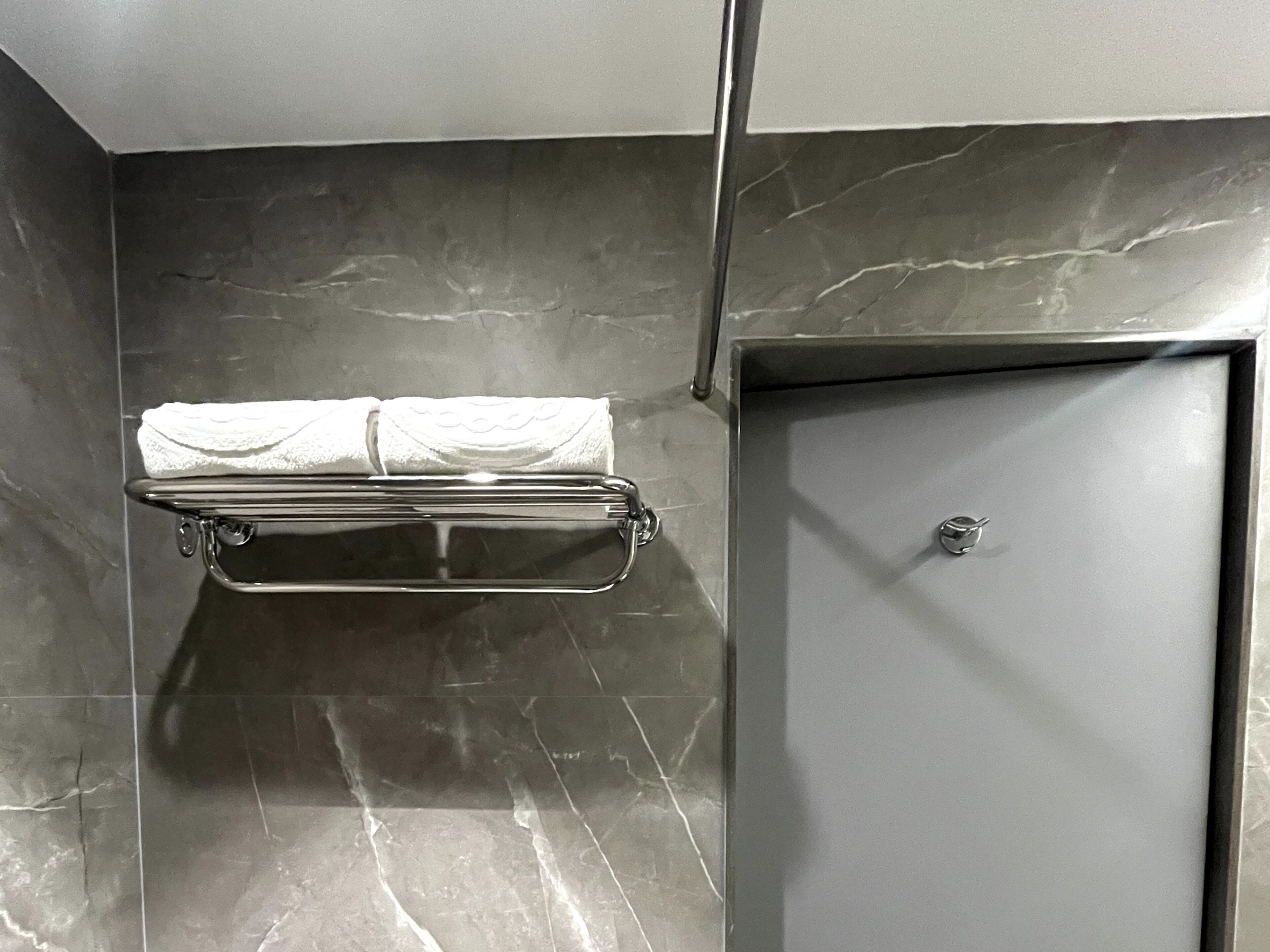 A bathroom with a towel rack and a door.