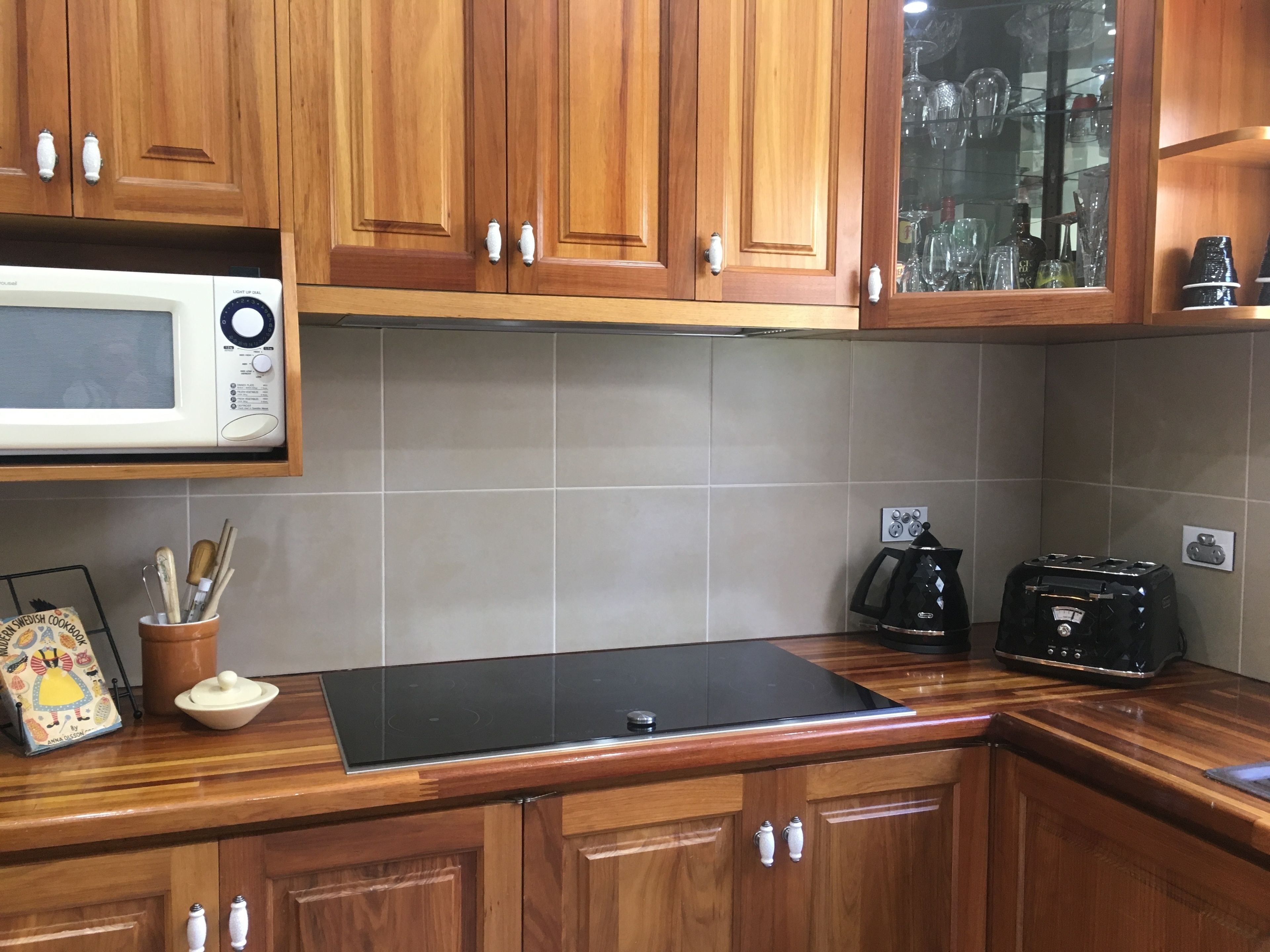 A kitchen with wooden cabinets, a microwave, a coffee maker, and a toaster.