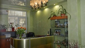 A reception area with a modern desk, potted plants, and a chandelier. - Guest House na Slobodskoy (St. Petersburg)