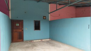 Una habitación con una pared azul, una puerta de madera y una ventana con persianas.