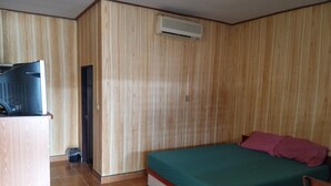 Un dormitorio con cama, escritorio y aire acondicionado.