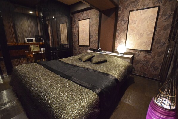 A modern bedroom with a large bed, a bedside table, and a lamp. - NUDA by H-Seven - Adults Only (Yokohama)