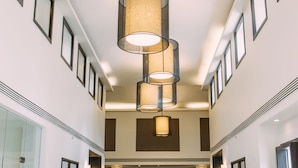 A spacious lobby with a polished marble floor, framed artwork on the walls, and a series of hanging cylindrical light fixtures. - Seda Ayala Center Cebu City (Cebu City)