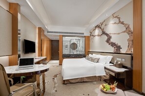Relax in a stylish room with a made bed, flat-screen TV, and desk for work or leisure.