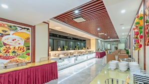 A buffet setup with a variety of dishes and a large poster on the wall. - Guangzhou Manguo International Hotel (Guangzhou)