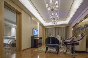 Relax in a spacious room with a large bed, flat-screen TV, and dining area.