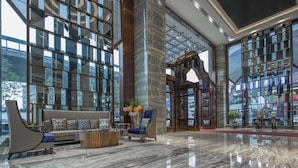 A modern lobby with a sofa, armchairs, and a coffee table. - Guangzhou Manguo International Hotel (Guangzhou)