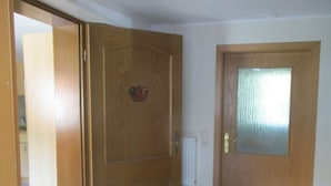 Une porte en bois avec un panneau en verre dépoli et une poignée en métal.