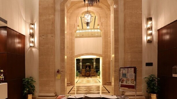 A hotel lobby with a marble floor, a reception desk, and a chandelier. - DLF Club 5 (Gurugram)