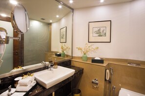 A modern bathroom with a large mirror, a sink, a shower, and framed artwork on the wall. - DLF Club 5 (Gurugram)