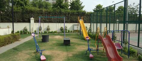 Un parque infantil con columpios, toboganes y equipamiento de ejercicio.