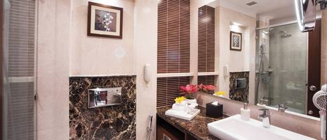 A modern bathroom with a large mirror, two sinks, a shower, and a marble backsplash.
