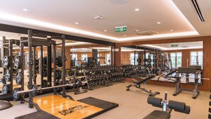 Un gimnasio con equipo de levantamiento de pesas, cintas de correr y máquinas de ejercicio.