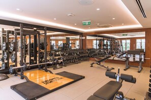 Un gimnasio con equipo de levantamiento de pesas, cintas de correr y máquinas de ejercicio.