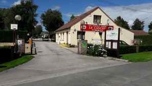 Un edificio con un cartel que indica 'Le Canchy', un sitio para campistas y caravanas.