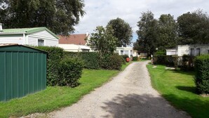 Un sendero de grava que atraviesa una zona residencial con casas y follaje.