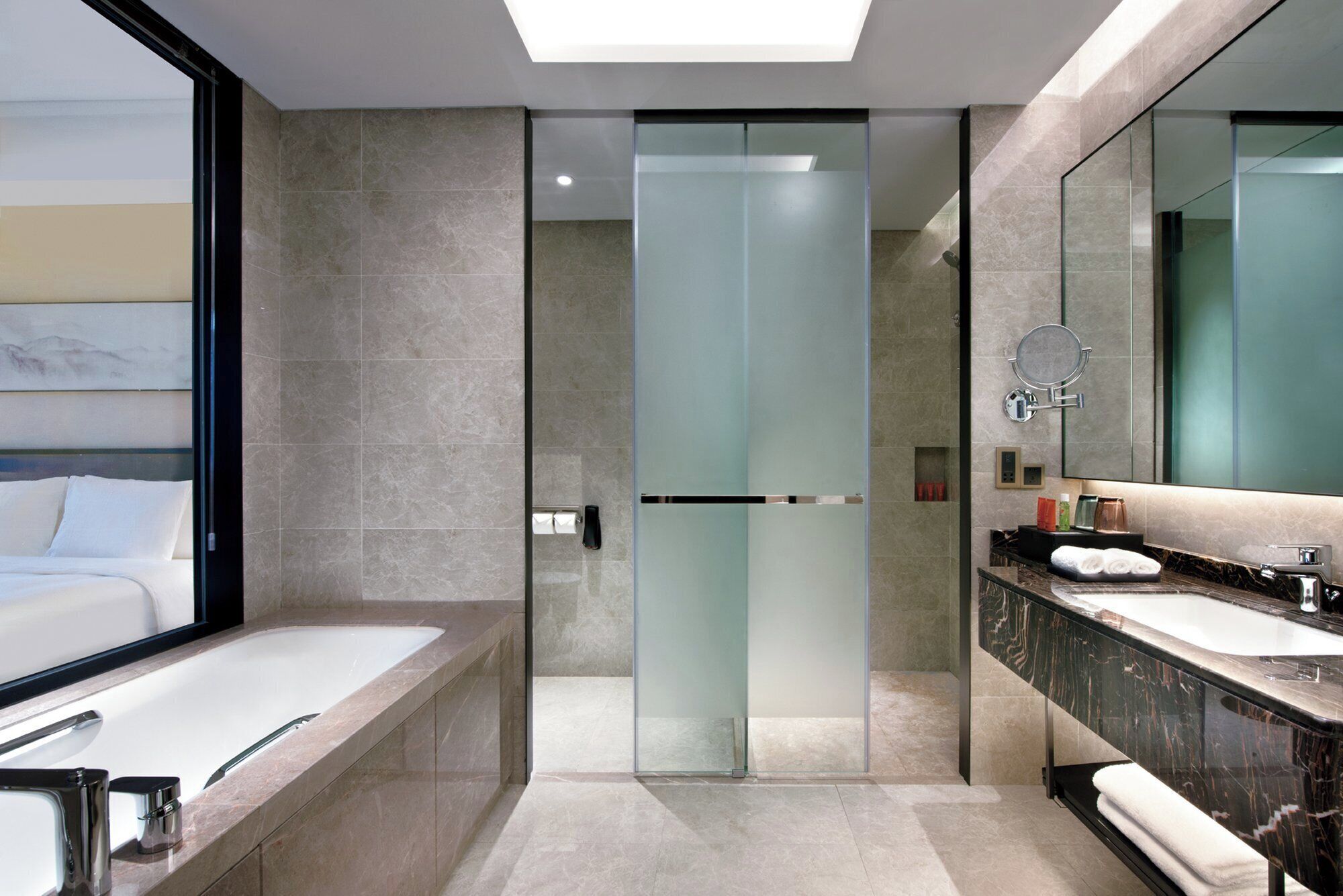 A modern bathroom with a glass shower enclosure, a large mirror, and a bathtub.