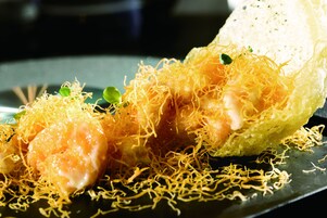 Un plato con camarones y fideos.
