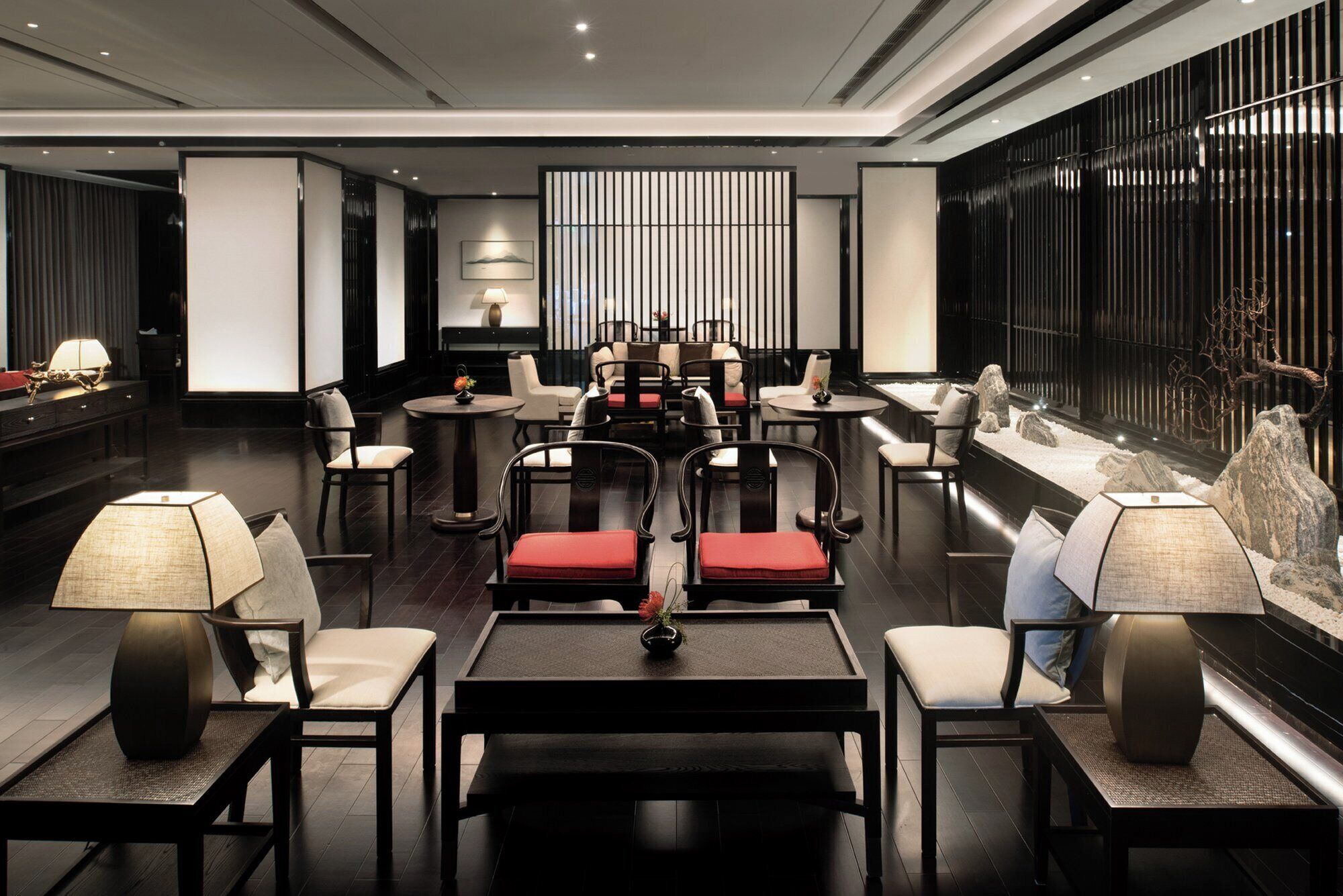 A modern lounge area with multiple seating options, including sofas and chairs, arranged around tables.