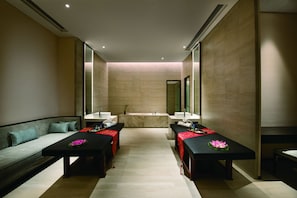 A modern spa room with a sofa, two massage tables, and a large mirror. - Crowne Plaza Huailai by IHG (Zhangjiakou)