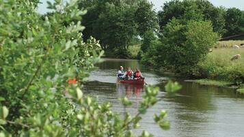 A narrow waterway with a boat carrying three people.