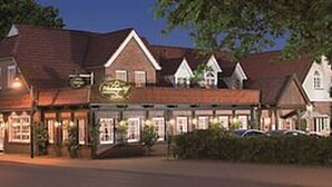 Een klassiek gebouw met veel ramen en een bord, waarschijnlijk een hotel of restaurant.