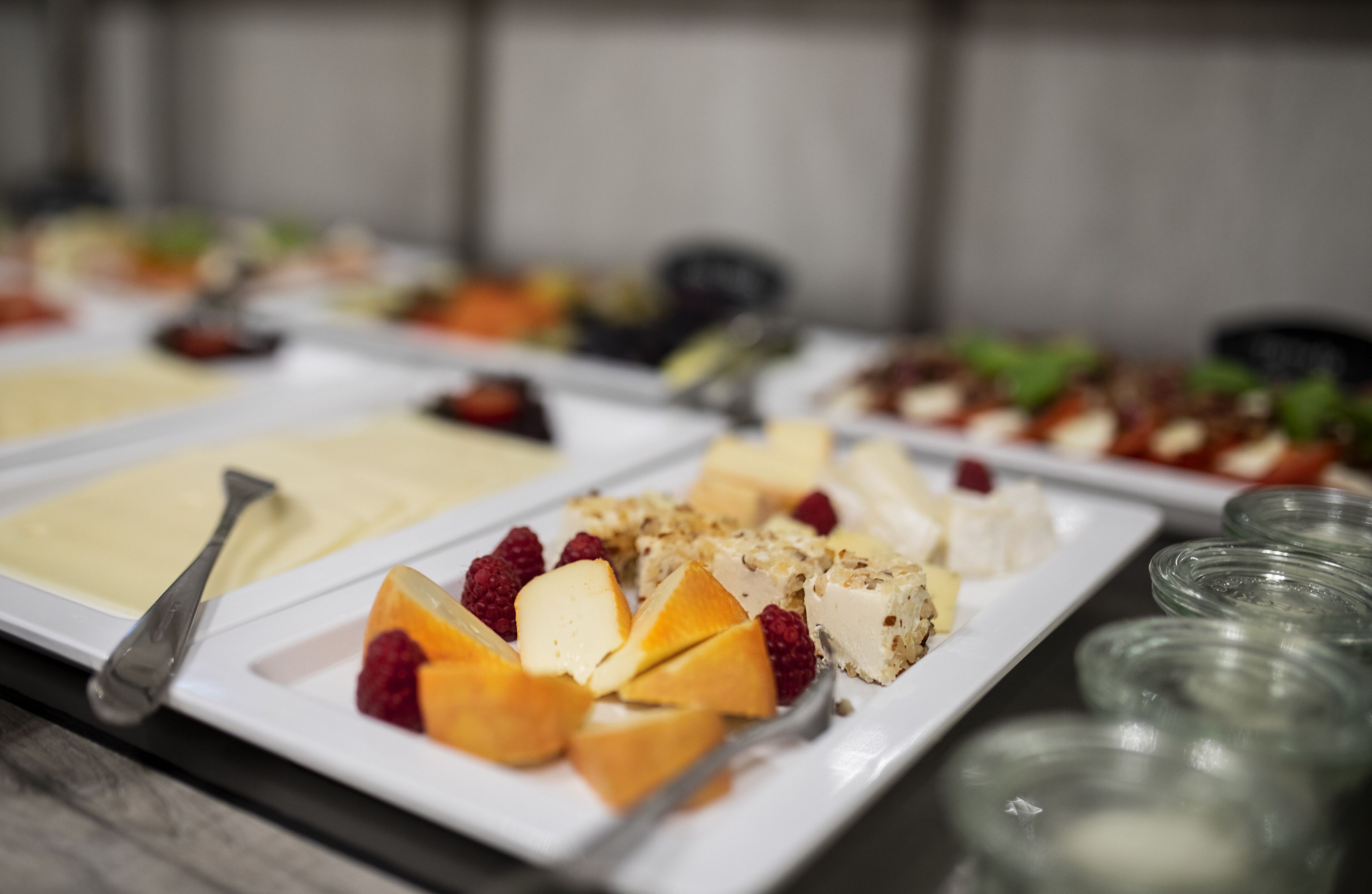 A buffet with various food items including cheese, fruits, and nuts.