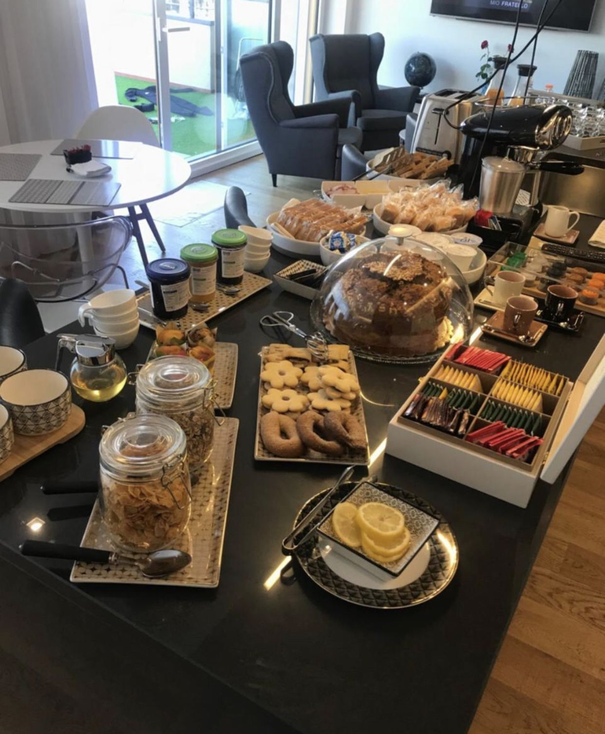 A breakfast buffet with various pastries, cookies, and beverages.