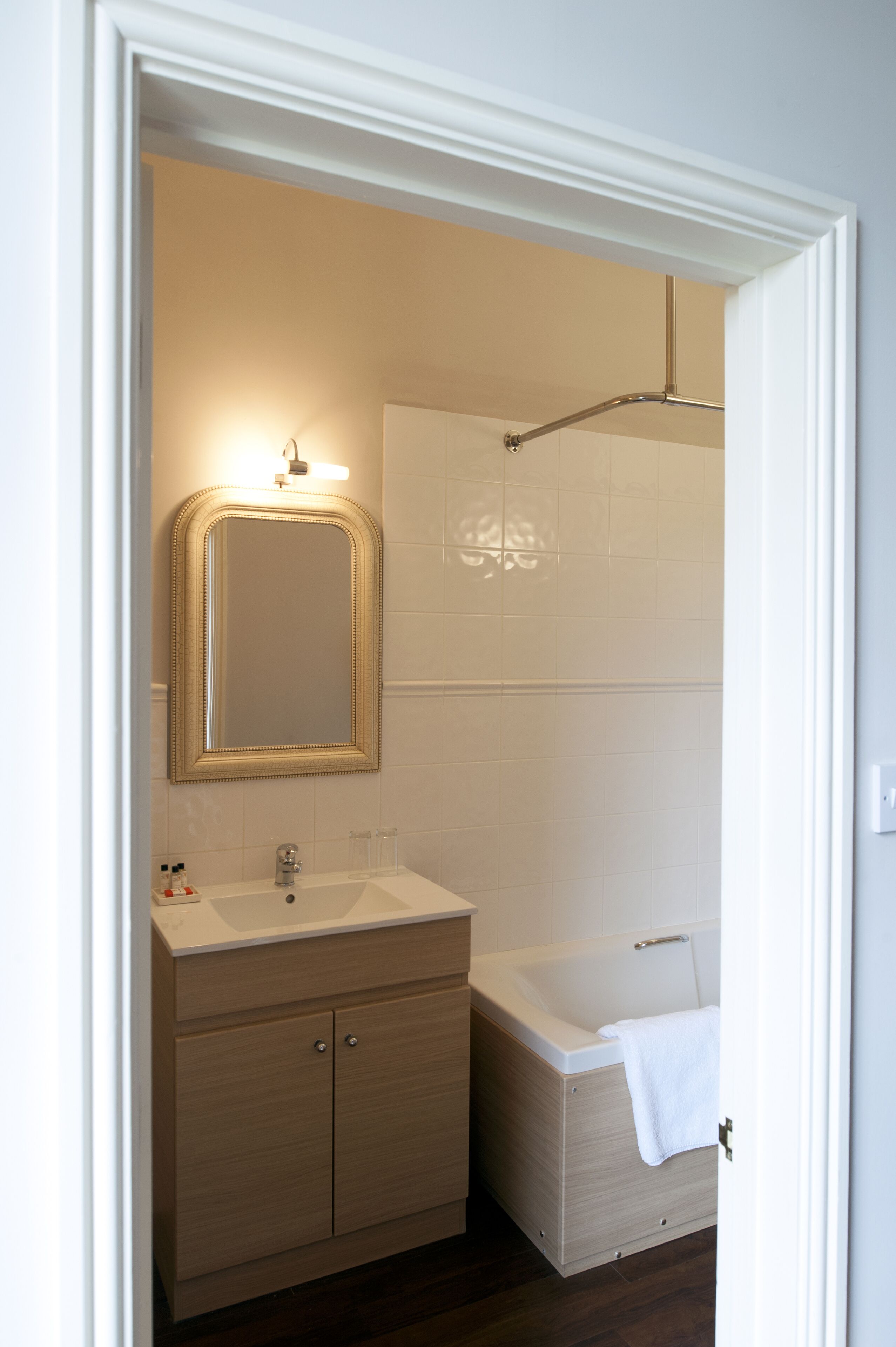 A bathroom with a mirror, two sinks, a bathtub, and a shower.
