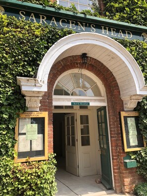 The entrance to Saracen's Head, featuring a brick archway and a sign indicating it offers bed and breakfast services. - The Saracen's Head (Norwich)