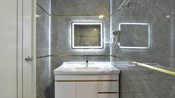 A modern bathroom with a white vanity, two wall-mounted mirrors, and a handheld showerhead.