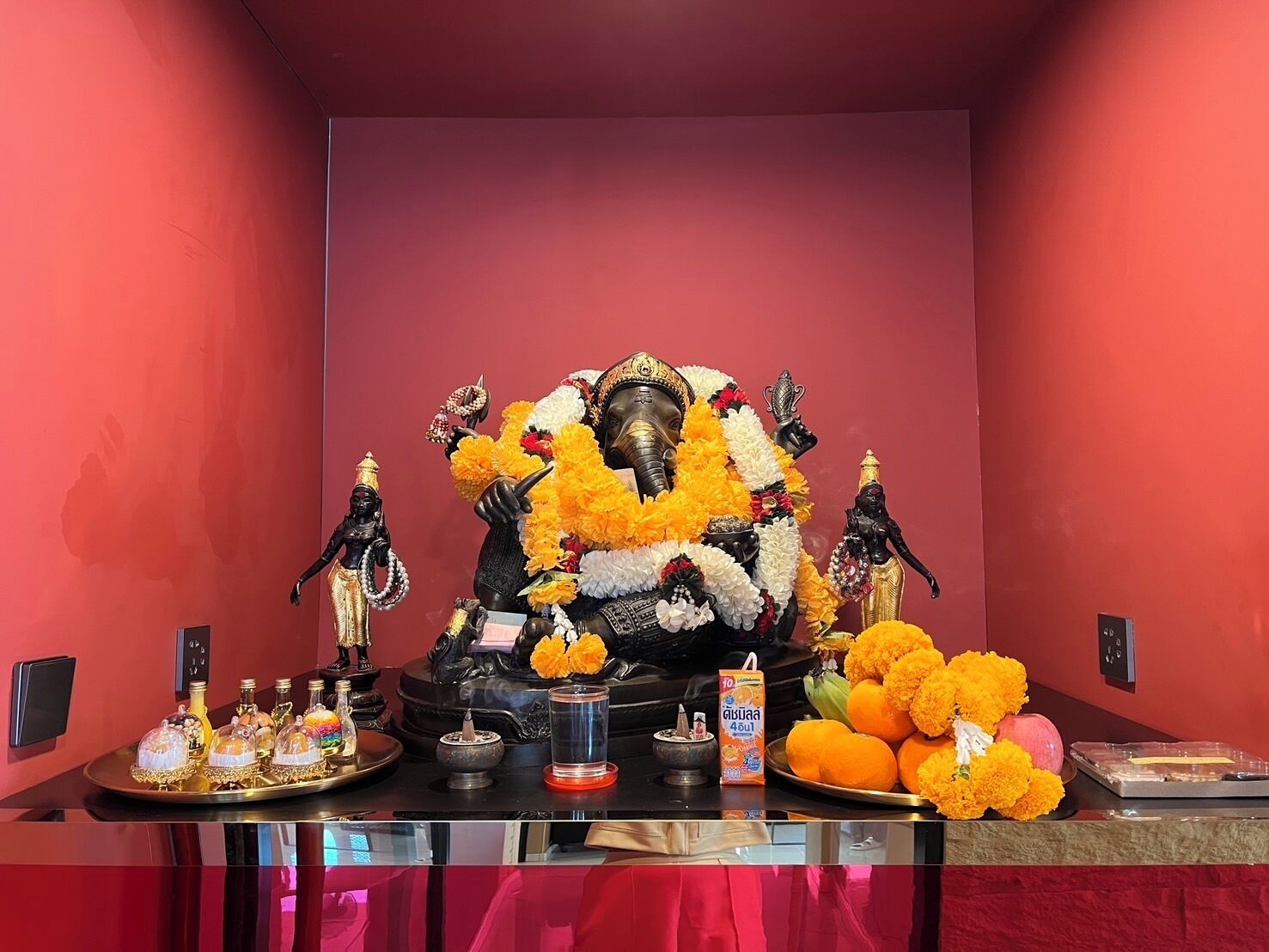 A shrine with statues, flowers, and offerings.