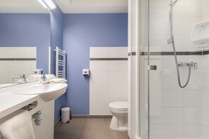 A bathroom with a white sink, a toilet, and a glass-enclosed shower. - ACE Hôtel Toulouse (Cornebarrieu)