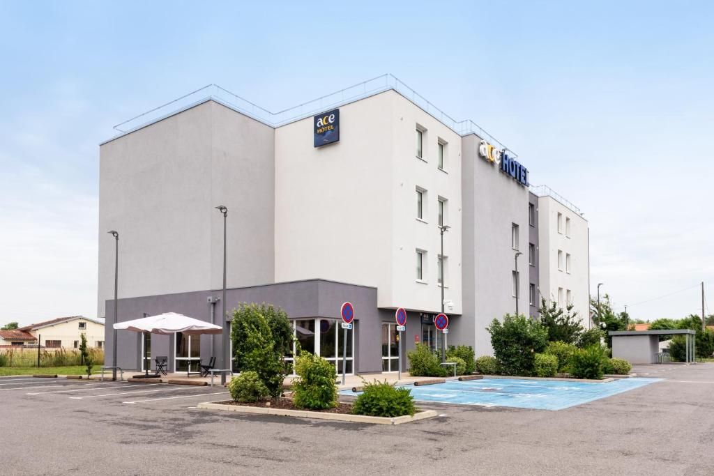 A modern hotel with a flat facade, outdoor seating area, and a swimming pool.