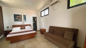 Ein Schlafzimmer mit Bett, Sofa, Klimaanlage und Fenster.