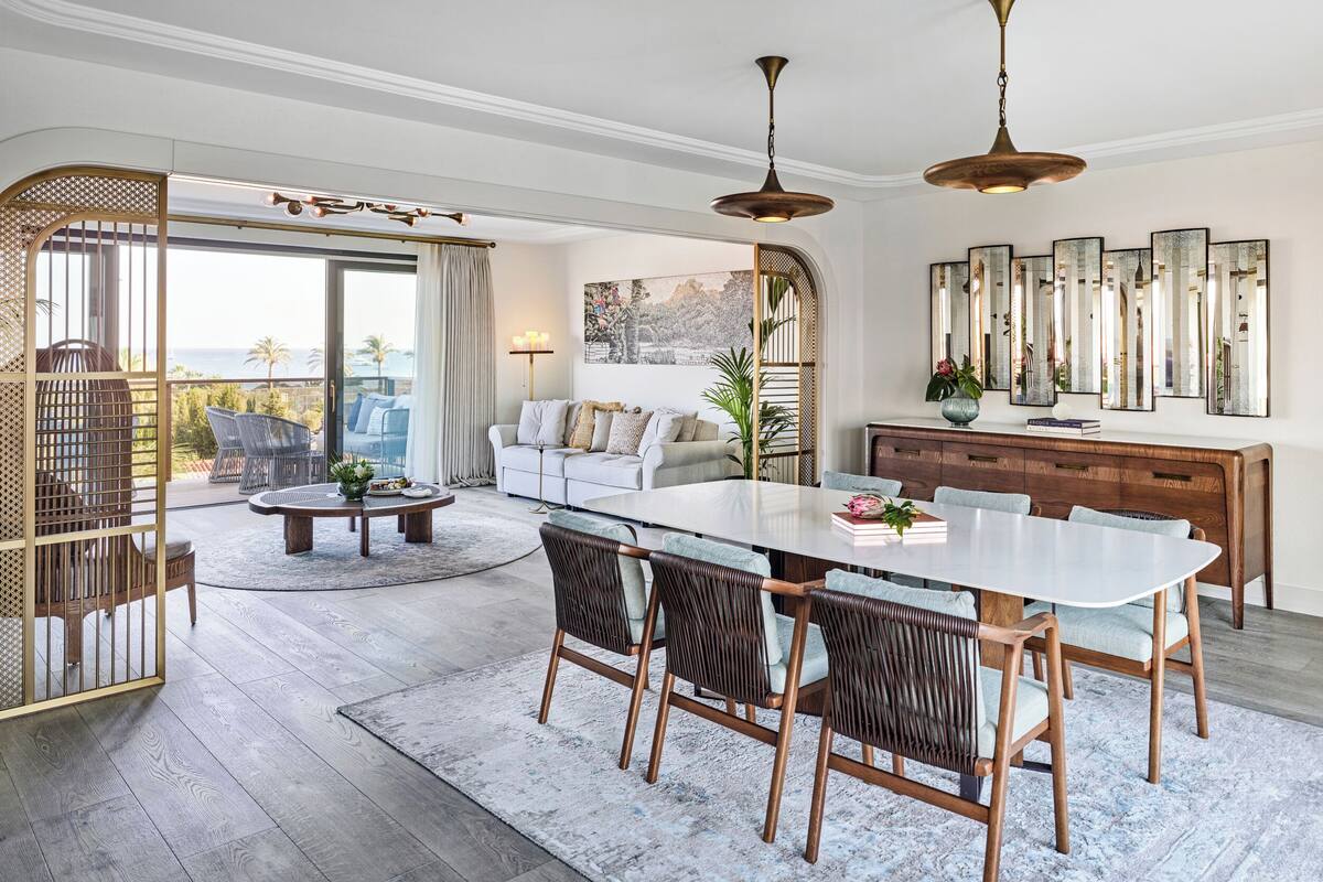 Una sala moderna con comedor, ventanas amplias y vistas al exterior.