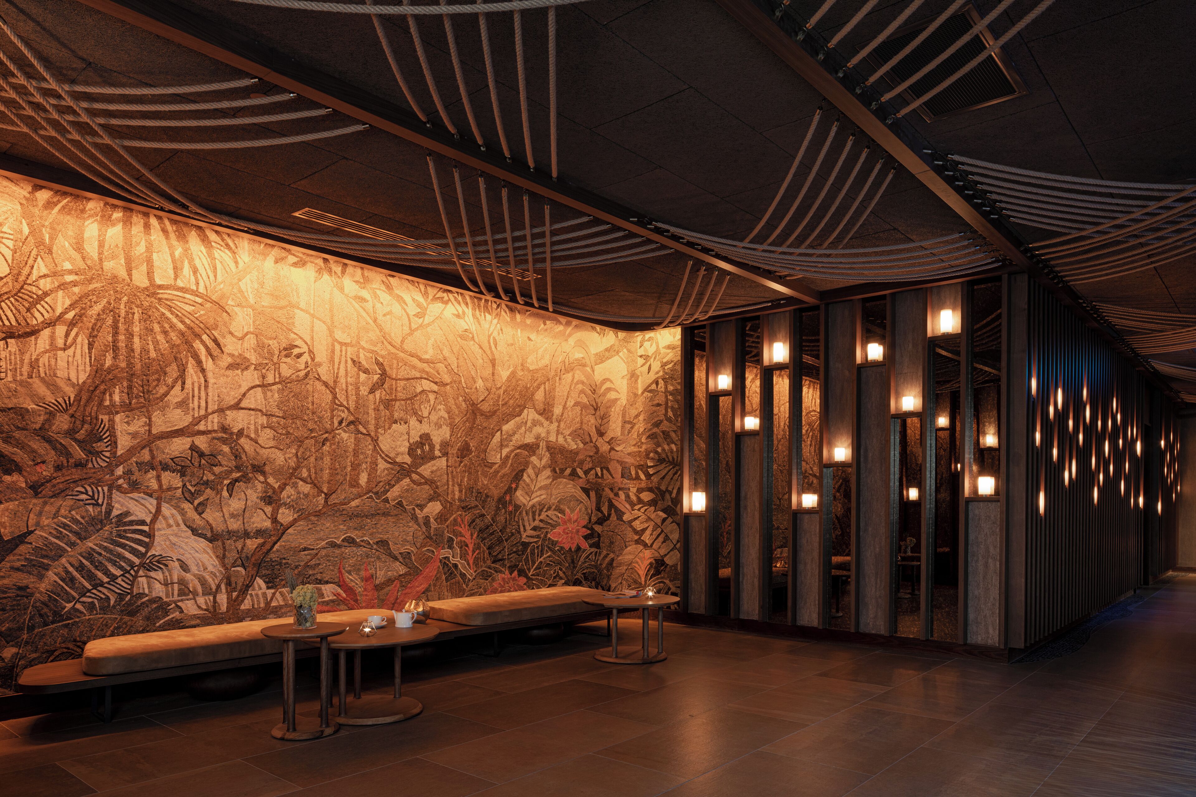 Un interior moderno con un mural, zona de estar e iluminación ambiental.