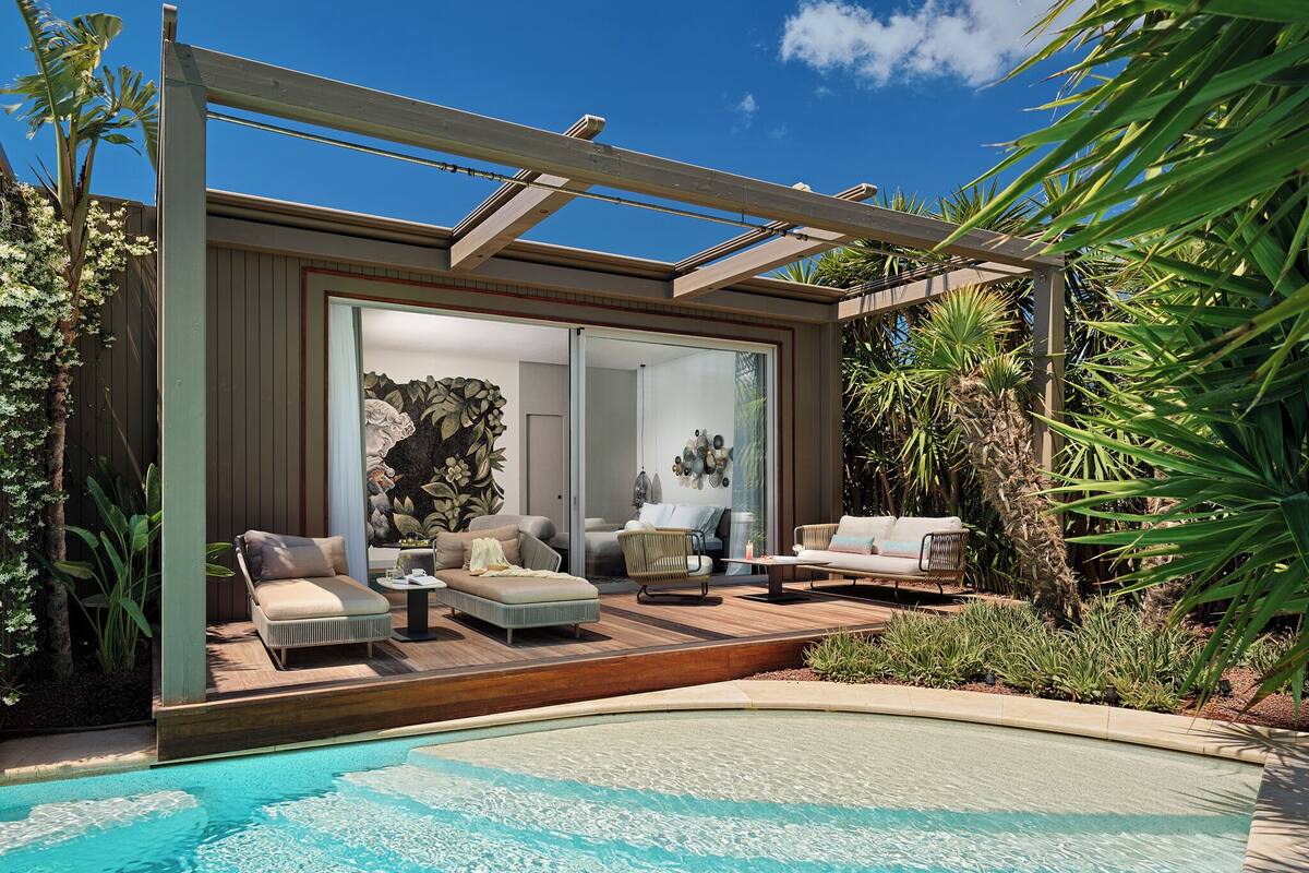 Un espacio exterior moderno con piscina, sillas de descanso y una pérgola.