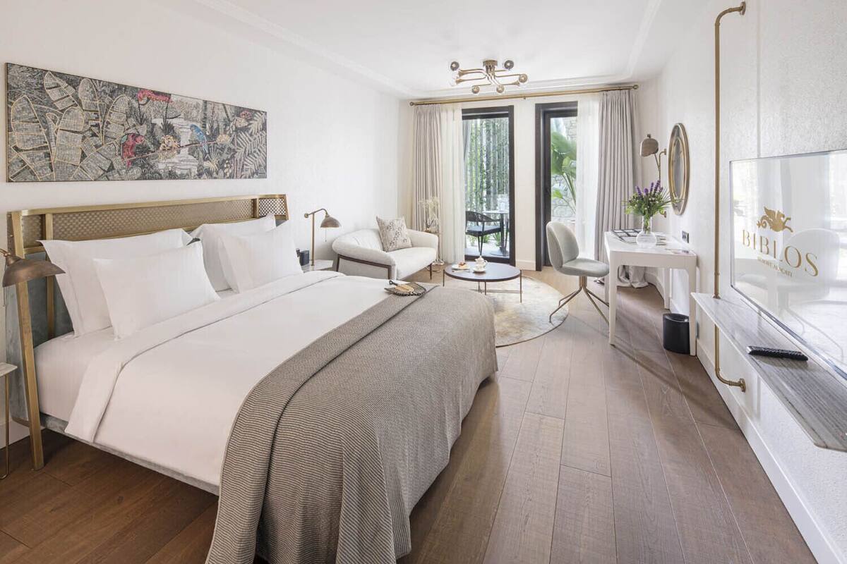 Una habitación de hotel con una cama grande, un escritorio, una silla y un televisor.
