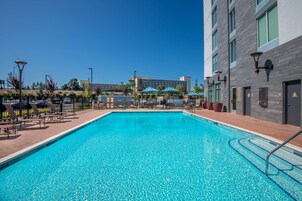 Una piscina al aire libre, sillones reclinables de piscina